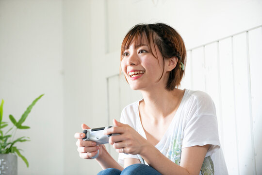 ゲームのコントローラーを持っている女性
