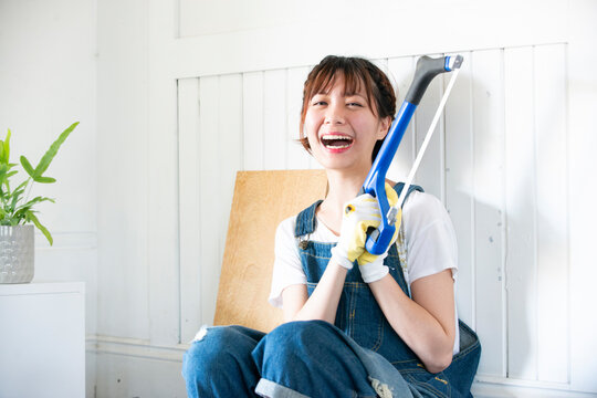 糸ノコを持って笑っている女性