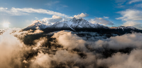 Tatranska Lomnica, Slovakia - Aerial panoramic view of the snowy peaks of the High Tatras above the clouds with the Lomnicky Peak, the second highest peak of the High Tatras mountains at sunset