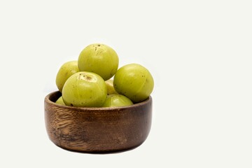 Indian Gooseberry Fruit or Amla Fruit in a Wooden Bowl Isolated on White Background with Copy Space, Also Known as Emblica Myrobalan or Phyllanthus Emblica
