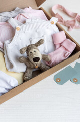 Baby and child clothes and knitted toys in carton box. - 791324921