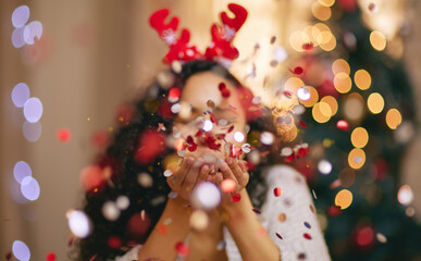 Woman, Christmas and blowing confetti for holiday celebration in home, sparkle or glitter. Female...