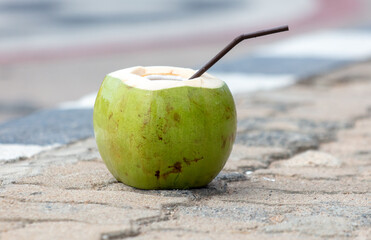 Coconut with a straw on the road