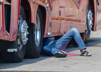 A man lies under a bus