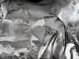 Silver foil background with shiny crumpled surface for texture background