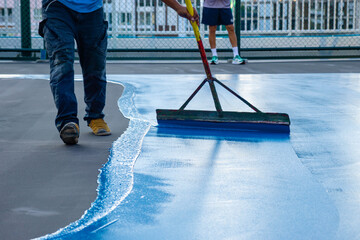 Workers Spreading floor paiting with Squeegee , Tennis court and sport floor painting by squeegee