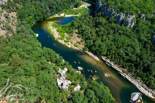 Rivière vue de haut, avec des canoés naviguant dessus (Ardèche, France)