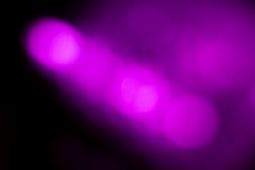 Blurred purple lights abstract background. Defocused glittering lights. Colorful wallpaper for...