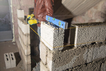 Measure level on brick wall in construction site. - 791336328