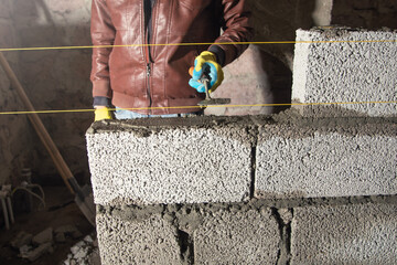 Worker builds a wall in the building site. - 791336346