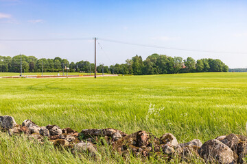 Stone wall by a green field in the country