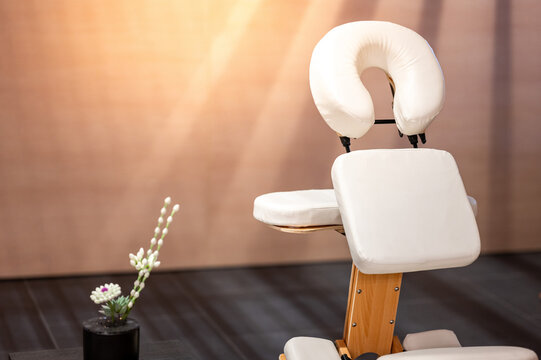 Portable adjustable massage chair in a cozy spa. Furniture and equipment for massage treatment service. Place for body care and relaxing activity