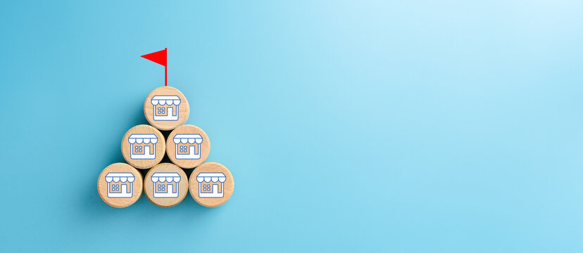 Wooden cubes with franchise icons and flag target on blue background. Franchise business concept. copy space
