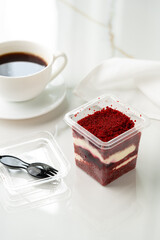 Trifle red velvet in plastic cup on table