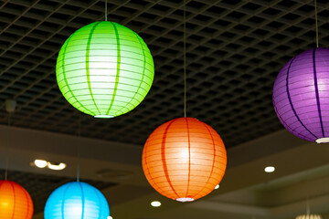 Vibrant Paper Lanterns Hanging From the Ceiling in a Festive Indoor Setting