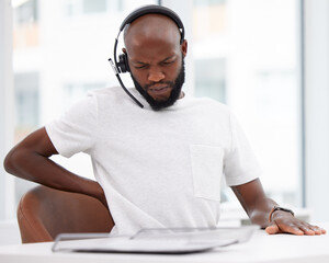 Black man, call centre and headset with back pain, office and customer support at desk. Hurt,...