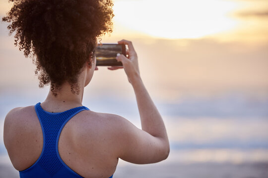 Phone screen, photography and woman with beach sunset for travel, memory or running fitness break. Sunrise, back and runner smartphone for social media, blog and profile picture at sea for training