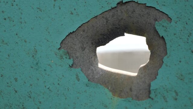 
Bullet hole on a metal door, fence.