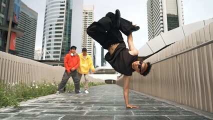 Panorama shot of break dancer perform b-boy performance and energetic footstep at city view. Dancer...