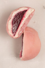 Traditional Japanese dessert, mochi cake, juicy raspberry berry filling, close-up of the cut