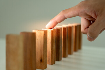 insurance with hands protect domino. Businessman hands stop dominoes falling in business crisis....
