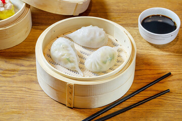 Chinese dim sum dumplings in a wooden bowl.