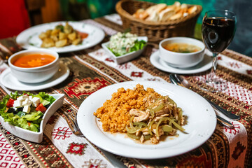 Fototapeta na wymiar Table With Plates of Food and Bowls of Soup