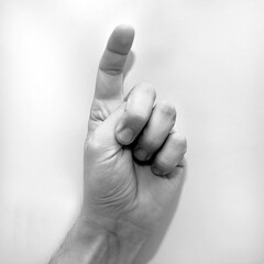 Letter X in American Sign Language (ASL) for deaf people, black and white photo of a hand