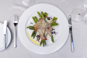 Top view of a rolled asparagus served  with cheese on a white plate - 791378165