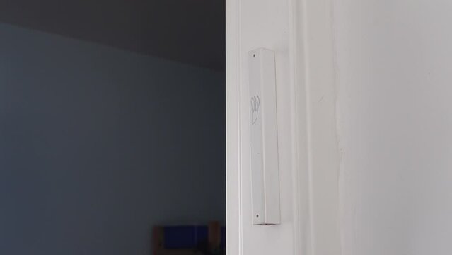Hand gently touches the Jewish mezuzah on the doorpost, a prayer for home protection in Judaism. White interior, stylish modern mezuzah in Israel.