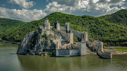 Scenic view of a medieval castle on a hill surrounded by a lake