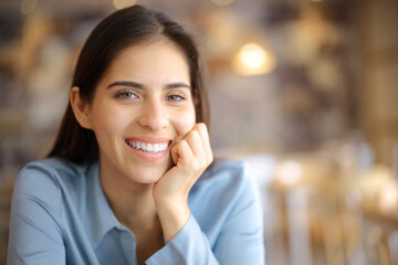 Happy woman with perfect smile posing looking at you in a bar - 791380711