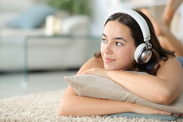 Woman with headphone listening podcast looking at side - 791380794
