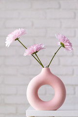 minimal composition of pink Scandinavian vase with purple daisies, interior decoration
