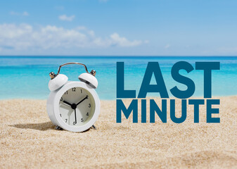 An alarm clock on the sands of a beach with the word last minute.