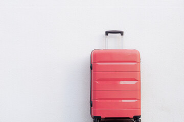 Pink travel suitcase on white background. Summer and vacations. Weekend. Travel.