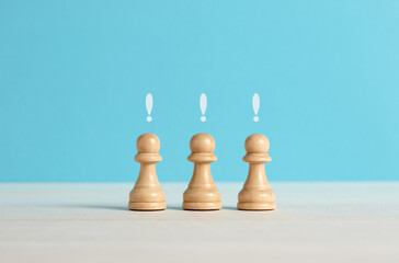Chess pawn pieces with exclamation mark.