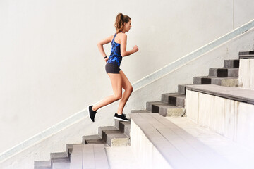 Female runner, stairs and cardio for sports, exercise and fit on steps for endurance, physical and...