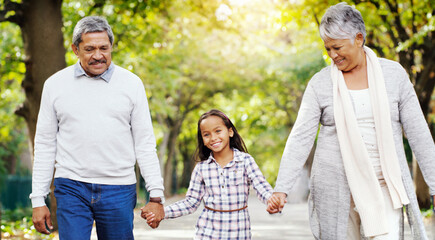 Park, walk and grandparents holding hands with girl, smile and bonding on outdoor adventure...