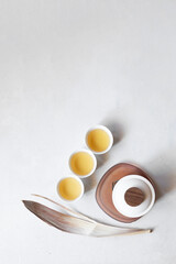Top view of minimalist still life composition of asian tea set with white cups and teapot, copy space