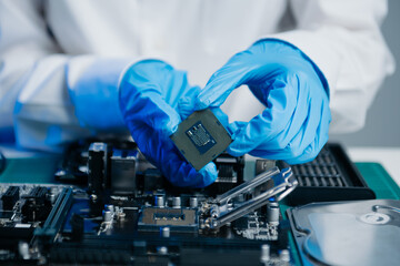 The technician is putting the CPU on the socket of the computer motherboard. electronic engineering...