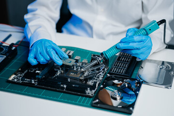 The technician is putting the CPU on the socket of the computer motherboard. electronic engineering...
