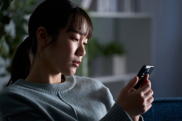 スマートフォンを見て落ち込む女性