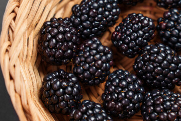 Fresh organic blackberries in a rustic rattan wicker bowl. Juicy black berry