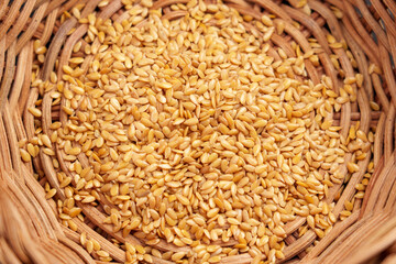 Whole wheat grain kernels in rural kitchenware. Organic cereal baking ingredients.