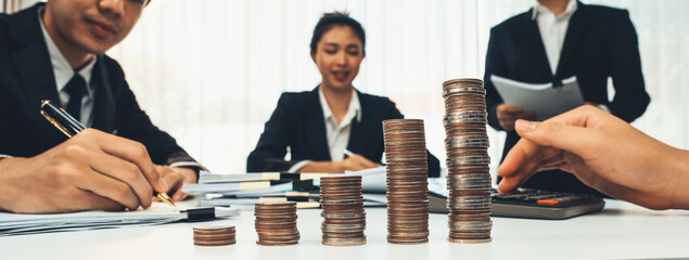 Growth coin stack symbolizing business investment and economic growth. Business people doing...