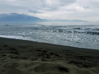 Beautiful seascape with black sand beach and sea waves.