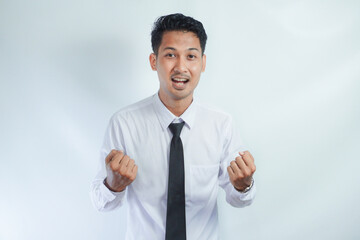 Young Asian business man showing happy excited expression with clenched fist