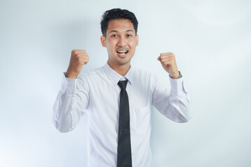 Young Asian business man showing happy excited expression with clenched fist