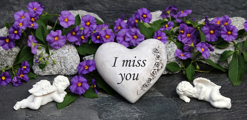 Heart with flowers as a grave decoration with the saying I miss you.